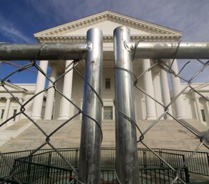 The Virginia state Capitol building is surrounded by fencing in preparation for Monday's rally. Gun-rights groups are asking a judge to block the Virginia governor's ban on firearms at a massive pro-gun rally scheduled for next week. (Photo/AP)