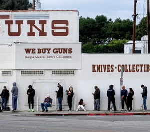 In this March 15, 2020, file photo, people wait in line to enter a gun store in Culver City, Calif. Los Angeles County Sheriff Alex Villanueva said that he is abandoning the effort to shut down firearms dealers.