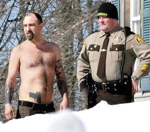 In this March 18, 2014 file photo, Michael Smith, left, bearing a realistic-looking tattoo of a handgun on his stomach, stands beside a Somerset County Sheriff deputy outside his home in Norridgewock, Maine.
