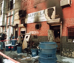In this 1990 file photo, news crews report on an arson fire at the Happy Land social club in which 87 people perished, in the Bronx borough of New York. (AP Photo)
