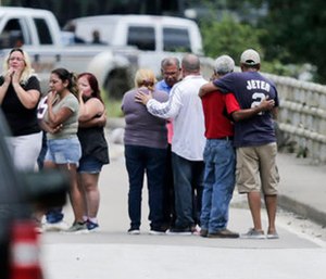 Family members react as a van is pulled out of the Greens Bayou with the bodies of six family members in Houston.