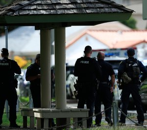 Honolulu police prepare to take defensive positions with their weapons after a shooting and domestic incident that left two Honolulu police officers dead. (Photo/AP)