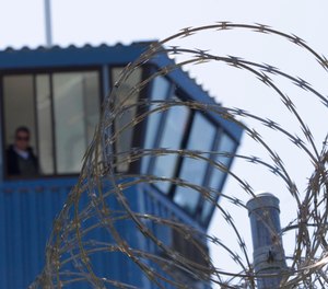 In this Aug. 17, 2011, file photo, concertina wire and a guard tower are seen at Pelican Bay State Prison near Crescent City, Calif. (AP Photo/Rich Pedroncelli, File)