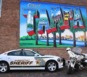 Hillsborough County Sheriff's Office vehicles are posed beneath a mural of Tampa, the county seat.