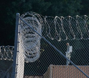 Early morning sun lights up the security fencing at the Hinds Detention Center in Raymond, Miss., Friday, June 12, 2015. ( AP Photo/Rogelio V. Solis)