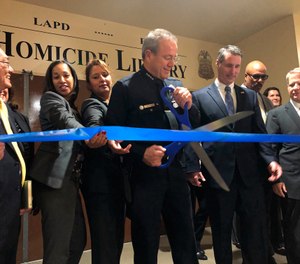 Los Angeles Police Chief Michel Moore cuts a ribbon to officially open the city's Homicide Library, where authorities are working to digitize murder cases in Los Angeles Wednesday, Oct. 2, 2019. (AP Photo/Stefanie Dazio)