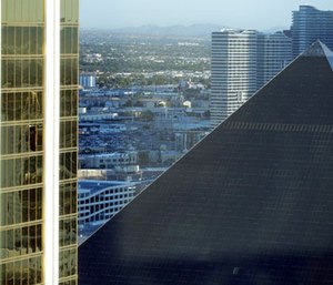 The Mandalay Bay Resort and Casino, at left, with a broken window, stands next to the Luxor in Las Vegas.