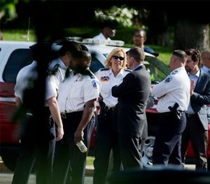 District of Columbia Police Chief Cathy Lanier, center, talks to other officials at the scene of a house fire where four people were found dead after firefighters entered a home in an upscale Washington neighborhood.