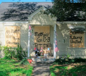 This Feb. 20, 2019, file photo shows a makeshift memorial with flowers and candles that has been set up at the front door of a home in Houston where a couple who lived there were killed during a Jan. 28, 2019, drug raid by Houston police. (AP Photo/Juan Lozano, File)