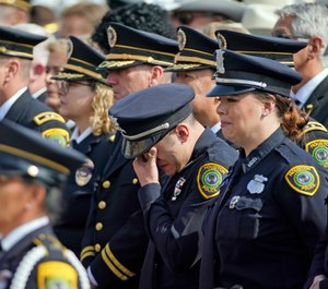 A Houston Police Officer wipes away tears during a funeral service for Houston Police Sgt. Christopher Brewster. (Photo/AP)