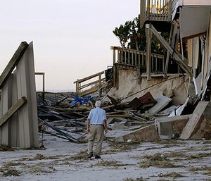 H.V. Bailey looks at damage to a neighbor's home at Ponte Vedra Beach, Fla., Saturday, Oct. 8, 2016, after Hurricane Matthew passed through Friday. (AP Photo/Charlie Riedel)