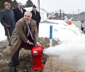 Retired firefighter and creator George Sigelakis tests the first Sigelock Spartan fire hydrant installed in Franklin, Pa. in 2010.