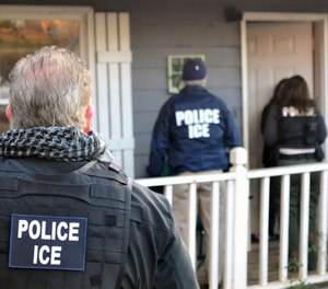 In this Feb. 9, 2017, photo provided U.S. Immigration and Customs Enforcement, ICE agents arrive at a home in Atlanta. (Bryan Cox/ICE via AP)
