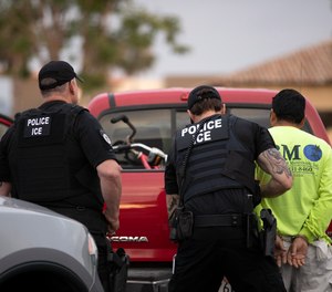 In this July 8, 2019, file photo, U.S. Immigration and Customs Enforcement (ICE) officers detain a man during an operation in Escondido, Calif. (AP Photo/Gregory Bull, File)