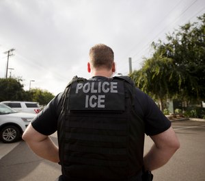 In this July 8, 2019, file photo, a U.S. Immigration and Customs Enforcement (ICE) officer looks on during an operation in Escondido, Calif.