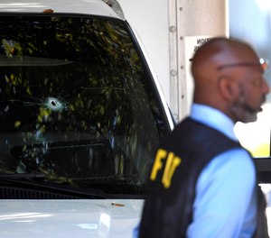 A bullet hole can be seen in the front window of a box truck where law enforcement officers where investigate after shots were fired involving Immigration and Customs Enforcement agents in the parking lot of a Food Lion store, Thursday, Sept. 5, 2019, in the Antioch neighborhood of Nashville, Tenn. (Shelley Mays/The Tennessean via AP)