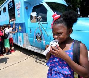 Amara Boyd, 7, opens up her ice cream after a press conference where police announced the start of Operation Polar Cops at the Boys & Girls Club on N. Grand Boulevard on Tuesday, July 26, 2016 in St. Louis.