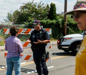 Police Officer Sam Lopez turns away would-be protesters in front of a road block near the Northwest Detention Center, Saturday July 13, 2019 in Tacoma, Wash. (Rebekah Welch/The Seattle Times via AP)