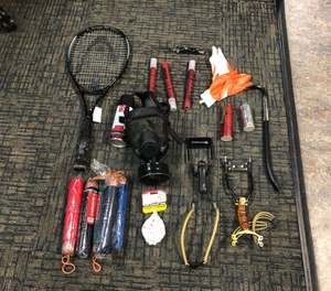 Jesse Herman Bates, 37, is accused of striking a Portland Fire and Rescue medic with a metal ball bearing using a slingshot-type device during a demonstration. Police say they seized a crowbar, two slingshots, a switchblade knife, flares, possible pryotechnics and several other items (pictured above) from the suspect.