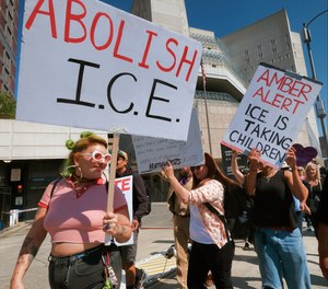 Protesters carry signs during a rally in front of the Immigration and Customs Enforcement facility in downtown Los Angeles on Monday, July 2, 2018.