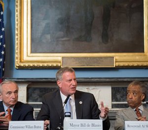 In this July 31, 2014 file photo provided by the New York City Mayoral Photography Office, New York Mayor Bill de Blasio, center, is seated between New York City Police Commissioner William Bratton, left, and the Rev.