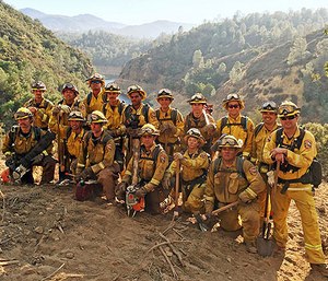 In this Aug. 15, 2016 photo provided by the California Conservation Corps, a civilian firefighter crew poses for a group photo during their deployment on the Chimney Fire in San Luis Obispo County, Calif.