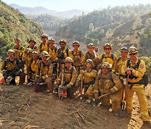 In this Aug. 15, 2016 photo provided by the California Conservation Corps, a civilian firefighter crew poses for a group photo during their deployment on the Chimney Fire in San Luis Obispo County, Calif.