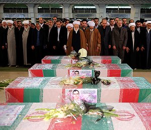 Iranian top officials pray before the flag draped coffins in the funeral of 16 firefighters killed in the collapse of a burning building on Jan. 19, in Tehran, Iran, Jan. 30, 2017.
