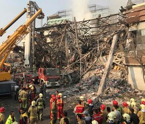 Iranian firefighters work at the scene of the collapsed Plasco building after being engulfed by a fire.