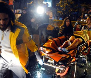 Medics carry a wounded person at the scene after an attack at a popular nightclub in Istanbul, early Sunday, Jan. 1, 2017.