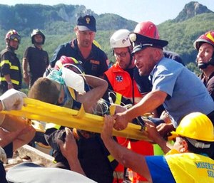 Firefighters and rescuers pull out a boy, Mattias, from the collapsed building in Casamicciola.