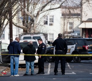 Jersey City police investigate and collect evidence on Rutgers Avenue where three Jersey City police officers were reportedly injured after a scuffle with an armed suspect.