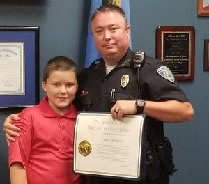 Pictured is Officer Jody Thompson and John during the Oklahoma State Bureau of Investigation ceremony that honored Thompson for his extraordinary show of humanity.