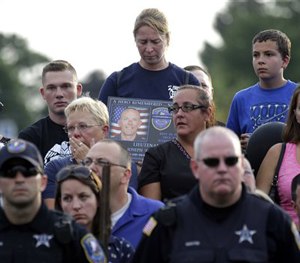 Mourners attend a vigil for Fox Lake Police Lt. Charles Joseph Gliniewicz on Wednesday, Sept. 2, 2015, in Fox Lake, Ill. (AP Image)
