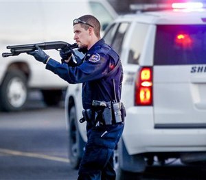 Police go through the parking lot of Excel Industries in Hesston, Kan., Thursday, Feb. 25, 2016.