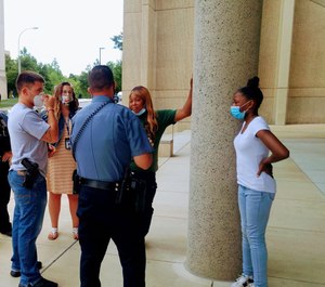 Shetara Sims and daughter Rakiya meet coworkers of the wounded officer after donating $100 they won with a lottery ticket. (Photo/ Kansas City Missouri Police Department)