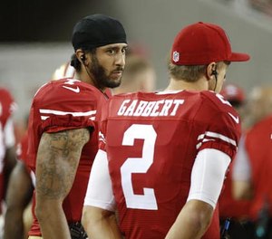 San Francisco 49ers quarterbacks Colin Kaepernick, left, and Blaine Gabbert stand on the sideline during the second half of an NFL preseason football game against the Green Bay Packers on Friday, Aug. 26, 2016, in Santa Clara, Calif.