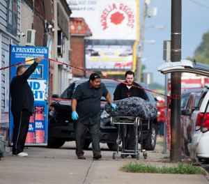 One of multiple shooting victims is loaded into a coroner's van following a shooting at Tequila KC Bar Sunday morning. (Photo/AP)