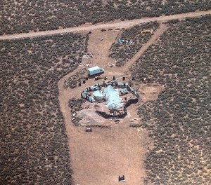 This Friday, Aug. 3, 2018, aerial photo released by Taos County Sheriff's Office shows a rural compound during an unsuccessful search for a missing 3-year-old boy in Amalia, N.M. (Taos County Sheriff's Office via AP)