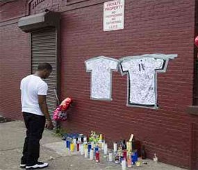 A pedestrian stands at a memorial to Lawrence Campbell, who allegedly shot and killed 23-year-old Jersey City police officer Melvin Santiago.