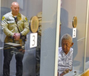 Thomas Kim sits in a hospital gown in a wheelchair as his arraignment is postponed. (Photo/AP)