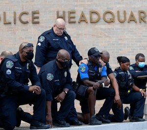 Members of the Austin Police Department kneel in front of demonstrators who gathered in Austin, Texas, Saturday, June 6, 2020, to protest the death of George Floyd.