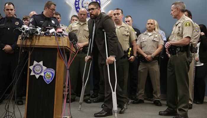 Officer Nicholas Koahou, center, walks toward the podium to answer questions during a news conference.