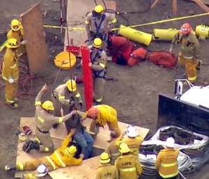 Firefighters used a fire truck's ladder like the boom of a crane to hoist the man up. (KTTV Fox11 News via AP)