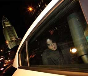 Police take a man into custody in connection with a threat to start shooting at the Los Angeles Times Building Friday night April 18.