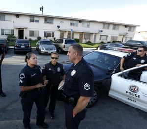 Officers with the Los Angeles Police Department's Community Safety Partnership gather outside one of the city's housing complexes. (Photo/TNS)