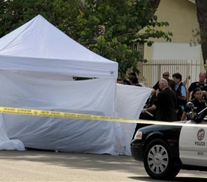 Los Angeles Police Department officers investigate the scene of a shooting Sunday, Aug. 24, 2014.