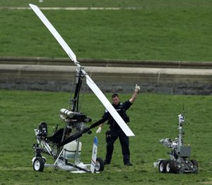 A Capitol Police officer flashes a thumbs up after inspecting the small helicopter a man landed on the West Lawn of the Capitol in Washington.