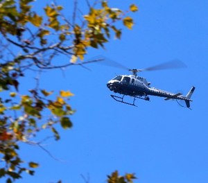A Los Angeles Police helicopter flies above a home during a standoff in the upscale neighborhood in Pacific Palisades in Los Angeles Thursday, Aug. 10, 2017.