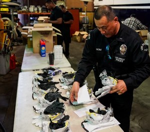 Lt. Jay Hom helps assemble kits consisting of an N95 mask, work gloves, and nitrile gloves, as he and other LAPD personnel assemble personal safety kits for field officers to protect themselves from exposure to the Coronavirus.